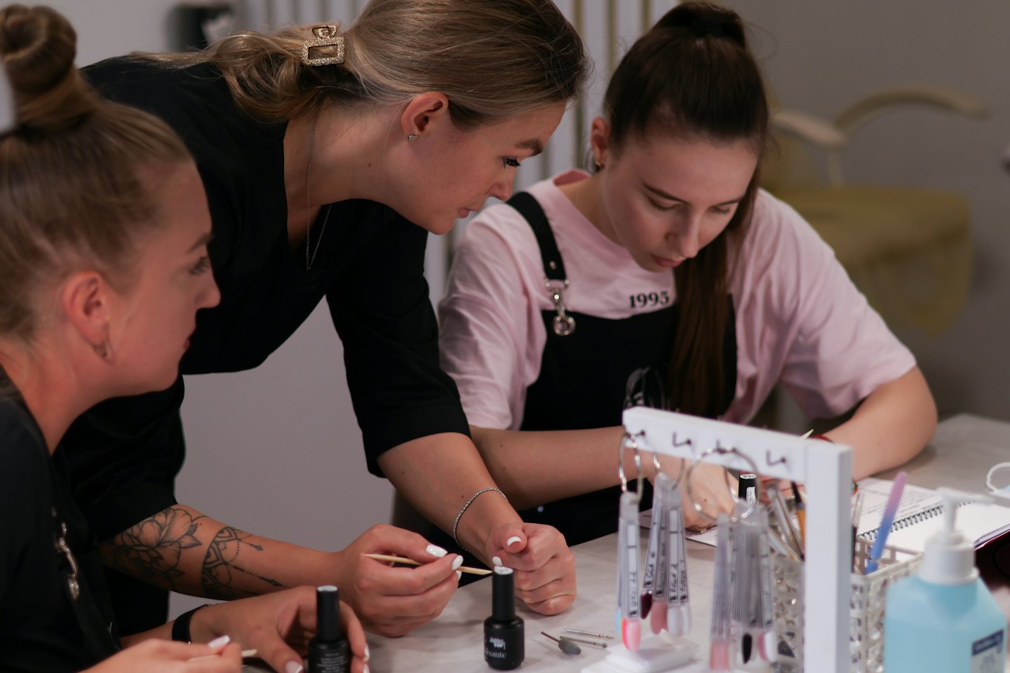 Un istruttore di nail art dimostra una tecnica agli studenti durante un workshop.